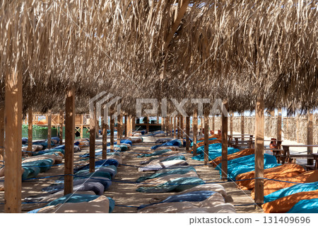 Serene outdoor beach hut retreat with lounge chairs in mediterranean sunlight 131409696