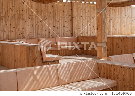 Cozy outdoor seating area with wooden benches and natural light 131409706