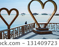 Scenic coastal view with wooden heart sculptures overlooking the ocean horizon 131409723