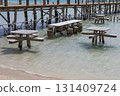 Tranquil seaside pier with wooden tables and crystal clear water for relaxation  131409724