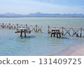 Tranquil coastal scene with rustic wooden fences and tables in shallow water 131409725