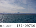 Serene ocean view with distant mountain range and clear sky 131409730