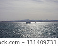 Tranquil ocean view with boats on a sparkling water horizon 131409731