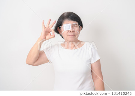 Elderly Woman with Eye protecting by Eye Pad for concepts of Eye disease, Cataract, Glaucoma, Age Related Macular Degeneration, Diabetic Retinopathy, Vitreous, Conjunctivitis, World Glaucoma day 131410245