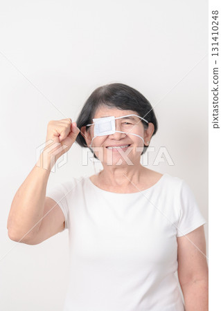 Elderly Woman with Eye protecting by Eye Pad for concepts of Eye disease, Cataract, Glaucoma, Age Related Macular Degeneration, Diabetic Retinopathy, Vitreous, Conjunctivitis, World Glaucoma day Elderly Woman with Eye protecting by Eye Pad for concepts of Eye disease, Cataract, Glaucoma, Age Related Macular Degeneration, Diabetic Retinopathy, Vitreous, Conjunctivitis, World Glaucoma day 131410248
