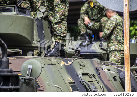 Soldiers boarding armored vehicle, Military climbing onto tank, Armed forces entering armored troop carrier 131410289