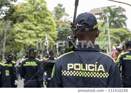 Police officer from behind with rifle, Armed policeman rear view, Law enforcement carrying firearm on back 131410298