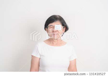 Elderly Woman with Eye protecting by Eye Pad for concepts of Eye disease, Cataract, Glaucoma, Age Related Macular Degeneration, Diabetic Retinopathy, Vitreous, Conjunctivitis, World Glaucoma day Elderly Woman with Eye protecting by Eye Pad for concepts of Eye disease, Cataract, Glaucoma, Age Related Macular Degeneration, Diabetic Retinopathy, Vitreous, Conjunctivitis, World Glaucoma day 131410527