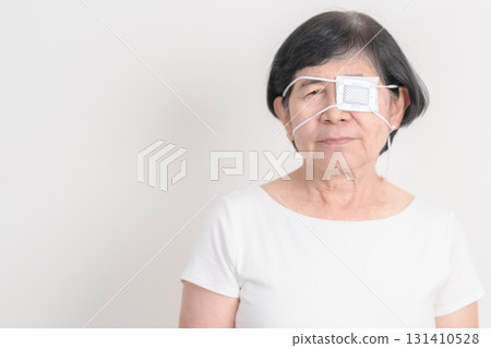 Elderly Woman with Eye protecting by Eye Pad for concepts of Eye disease, Cataract, Glaucoma, Age Related Macular Degeneration, Diabetic Retinopathy, Vitreous, Conjunctivitis, World Glaucoma day Elderly Woman with Eye protecting by Eye Pad for concepts of Eye disease, Cataract, Glaucoma, Age Related Macular Degeneration, Diabetic Retinopathy, Vitreous, Conjunctivitis, World Glaucoma day 131410528
