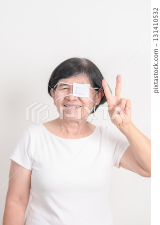 Elderly Woman with Eye protecting by Eye Pad for concepts of Eye disease, Cataract, Glaucoma, Age Related Macular Degeneration, Diabetic Retinopathy, Vitreous, Conjunctivitis, World Glaucoma day 131410532