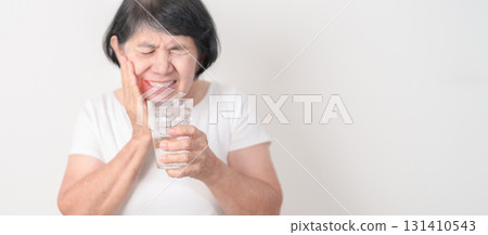 Elderly woman having toothache and pain after drink ice water for concept of Teeth Sensitive to Cold, Tooth Decay and Gum Disease, Grinding Teeth and Stress, Exposed Nerve Roots, Crack and Receding Elderly woman having toothache and pain after drink ice water for concept of Teeth Sensitive to Cold, Tooth Decay and Gum Disease, Grinding Teeth and Stress, Exposed Nerve Roots, Crack and Receding 131410543