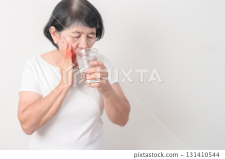 Elderly woman having toothache and pain after drink ice water for concept of Teeth Sensitive to Cold, Tooth Decay and Gum Disease, Grinding Teeth and Stress, Exposed Nerve Roots, Crack and Receding Elderly woman having toothache and pain after drink ice water for concept of Teeth Sensitive to Cold, Tooth Decay and Gum Disease, Grinding Teeth and Stress, Exposed Nerve Roots, Crack and Receding 131410544