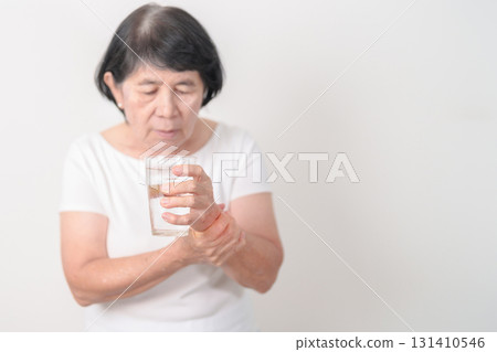 Elderly woman having Tremor hand during hold water glass. Parkinson disease April awareness month, Carpal Tunnel Syndrome, rheumatoid and brain injury, Neurological disorder and Senior health concept Elderly woman having Tremor hand during hold water glass. Parkinson disease April awareness month, Carpal Tunnel Syndrome, rheumatoid and brain injury, Neurological disorder and Senior health concept 131410546