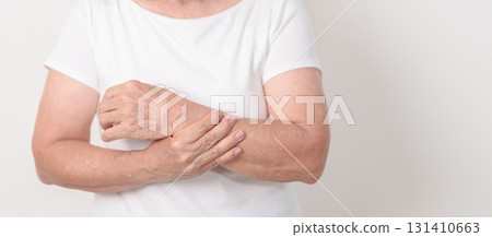 Elderly Woman having wrist pain with Medicated pain relief patch plaster for Carpal Tunnel Syndrome, Wrist Tendinitis, muscle ache, De Quervain s tenosynovitis, Hand Osteoarthritis and Senior health 131410663