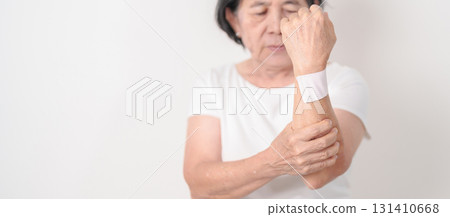 Elderly Woman having wrist pain with Medicated pain relief patch plaster for Carpal Tunnel Syndrome, Wrist Tendinitis, muscle ache, De Quervain s tenosynovitis, Hand Osteoarthritis and Senior health Elderly Woman having wrist pain with Medicated pain relief patch plaster for Carpal Tunnel Syndrome, Wrist Tendinitis, muscle ache, De Quervain s tenosynovitis, Hand Osteoarthritis and Senior health 131410668