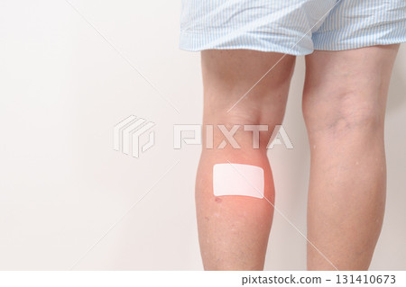 Elderly woman having Calf pain with Medicated pain relief patch plaster for concepts of Calf Muscle Strain, muscle pull, Leg Cramp, Sprain, aches, Varicose Veins, Deep Vein and world Thrombosis day 131410673