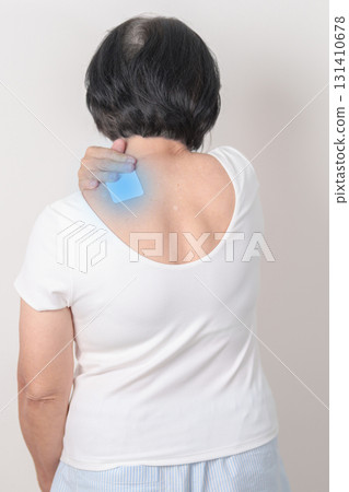 Elderly Woman having Shoulder Pain with Medicated pain relief patch plaster for Muscle Inflammation and Sprain, Myofascial ache syndrome and Fibromyalgia, Shoulder Myalgia and Scapular Tightness 131410678