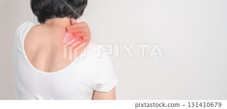 Elderly Woman having Shoulder Pain with Medicated pain relief patch plaster for Muscle Inflammation and Sprain, Myofascial ache syndrome and Fibromyalgia, Shoulder Myalgia and Scapular Tightness 131410679