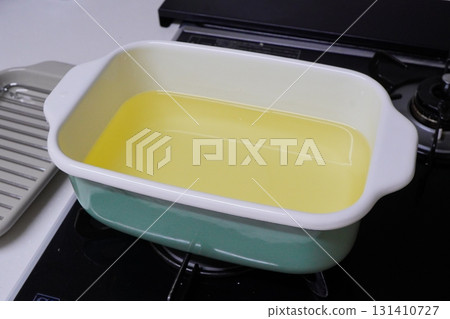 A kitchen stock photo of an enamel pot filled with oil, taken from the side, expressing the atmosphere of preparing fried food and home cooking 131410727