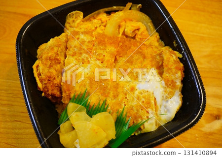 A delicious stock photo of a juicy katsudon topped with egg, taken from above, that conveys the deliciousness of a classic Japanese dish. A delicious stock photo of a juicy katsudon topped with egg, taken from above, that conveys the deliciousness of a classic Japanese dish. 131410894