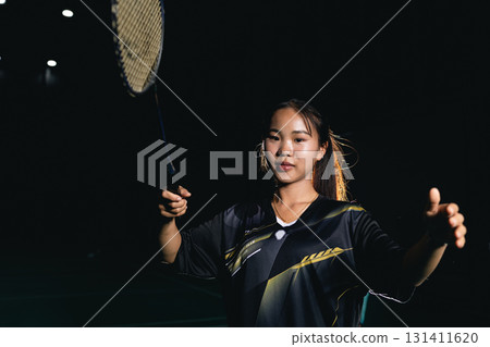 Young woman teen girl enjoy playing badminton handle racket, indoor shuttlecock sport game 131411620