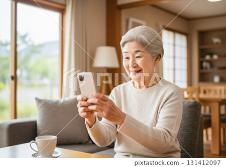 一位老年婦女用智慧型手機與家人視訊通話 131412097
