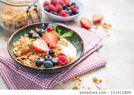 Granola bowl with fresh berries yogurt and nuts 131412809