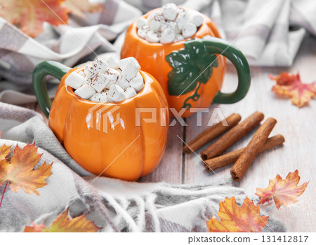 Pumpkin mugs filled with hot chocolate for autumn comfort Pumpkin mugs filled with hot chocolate for autumn comfort 131412817