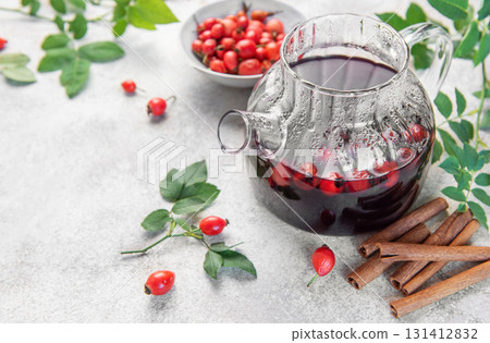 Rosehip tea brewing in glass teapot with cinnamon 131412832