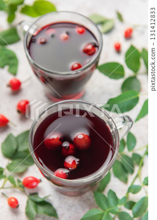 Drinking hot rosehip tea with berries and leaves Drinking hot rosehip tea with berries and leaves 131412833
