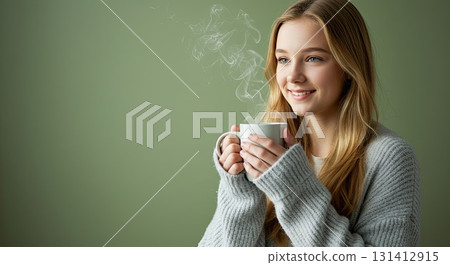 Smiling woman enjoys cozy moment with hot drink. A very cozy, warm lifestyle 131412915
