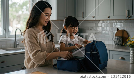 Mother shows daughter loving care while packing lunch. This is true family care 131412916