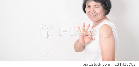 Elderly Woman with bandage after received vaccine. Vaccination and Immunization for Influenza, Herpes Zoster, Tetanus, Covid 19 booster, Dengue, Encephalitis, Rabies, Pneumococcal, IPD, RSV Vaccines 131413792