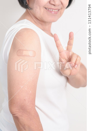 Elderly Woman with bandage after received vaccine. Vaccination and Immunization for Influenza, Herpes Zoster, Tetanus, Covid 19 booster, Dengue, Encephalitis, Rabies, Pneumococcal, IPD, RSV Vaccines 131413794