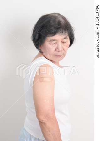 Elderly Woman with bandage after received vaccine. Vaccination and Immunization for Influenza, Herpes Zoster, Tetanus, Covid 19 booster, Dengue, Encephalitis, Rabies, Pneumococcal, IPD, RSV Vaccines 131413796
