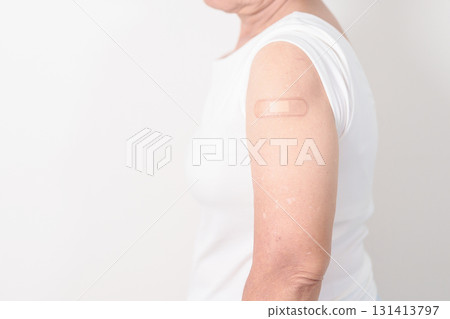 Elderly Woman with bandage after received vaccine. Vaccination and Immunization for Influenza, Herpes Zoster, Tetanus, Covid 19 booster, Dengue, Encephalitis, Rabies, Pneumococcal, IPD, RSV Vaccines 131413797