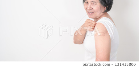 Elderly Woman with bandage after received vaccine. Vaccination and Immunization for Influenza, Herpes Zoster, Tetanus, Covid 19 booster, Dengue, Encephalitis, Rabies, Pneumococcal, IPD, RSV Vaccines 131413800