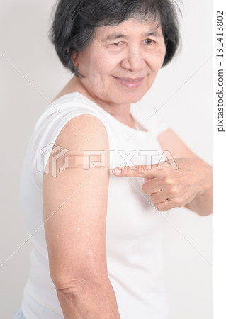 Elderly Woman with bandage after received vaccine. Vaccination and Immunization for Influenza, Herpes Zoster, Tetanus, Covid 19 booster, Dengue, Encephalitis, Rabies, Pneumococcal, IPD, RSV Vaccines 131413802