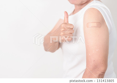 Elderly Woman with bandage after received vaccine. Vaccination and Immunization for Influenza, Herpes Zoster, Tetanus, Covid 19 booster, Dengue, Encephalitis, Rabies, Pneumococcal, IPD, RSV Vaccines 131413805