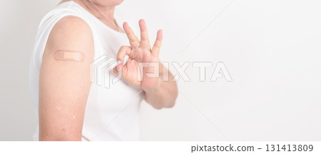 Elderly Woman with bandage after received vaccine. Vaccination and Immunization for Influenza, Herpes Zoster, Tetanus, Covid 19 booster, Dengue, Encephalitis, Rabies, Pneumococcal, IPD, RSV Vaccines 131413809