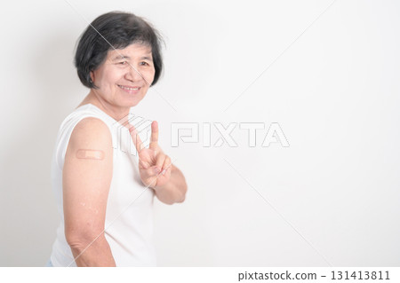 Elderly Woman with bandage after received vaccine. Vaccination and Immunization for Influenza, Herpes Zoster, Tetanus, Covid 19 booster, Dengue, Encephalitis, Rabies, Pneumococcal, IPD, RSV Vaccines 131413811