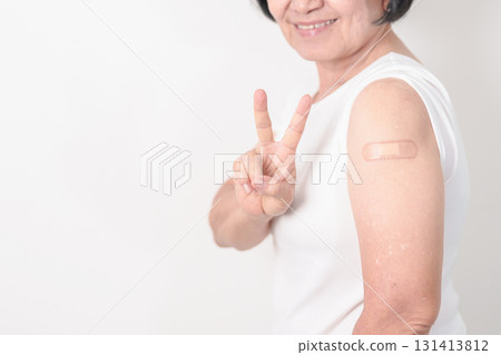Elderly Woman with bandage after received vaccine. Vaccination and Immunization for Influenza, Herpes Zoster, Tetanus, Covid 19 booster, Dengue, Encephalitis, Rabies, Pneumococcal, IPD, RSV Vaccines 131413812