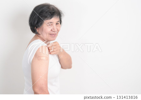 Elderly Woman with bandage after received vaccine. Vaccination and Immunization for Influenza, Herpes Zoster, Tetanus, Covid 19 booster, Dengue, Encephalitis, Rabies, Pneumococcal, IPD, RSV Vaccines 131413816