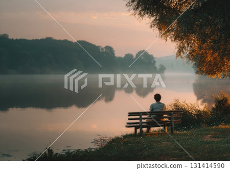 Man watching peaceful misty lake at sunrise 131414590