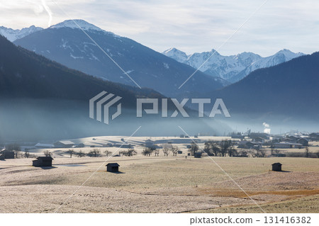 Scenic picturesque landscape view many small little wooden log alpine hut on alpine austrian meadow Alps with mountain peaks sky background foggy morning. Serene peaceful solitude nature countryside Scenic picturesque landscape view many small little wooden log alpine hut on alpine austrian meadow Alps with mountain peaks sky background foggy morning. Serene peaceful solitude nature countryside 131416382