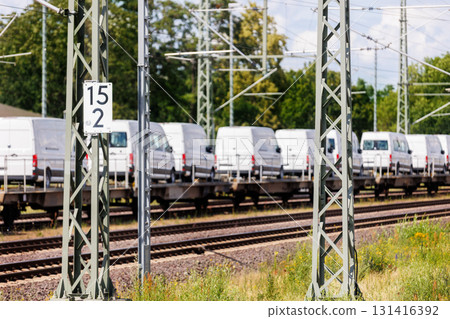 Many new modern electric and fuel cars vans transportation by cargo freight train railway wagon. Railroad export and import automotive logistics service. Safety and insurance goods shipping industry 131416392