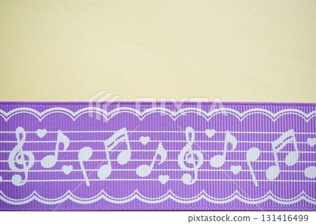A photo of a purple ribbon with a horizontal white musical note design on it. 131416499