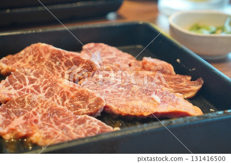Appetizing and delicious looking yakiniku ingredients with a close-up shot of marbled beef arranged on a hot plate 131416500
