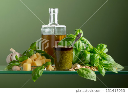 Pesto sauce and ingredients on a green background. Pesto sauce and ingredients on a green background. 131417033