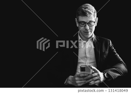 businessman thinking in the shadow look reading business information smartphone screen with copy space back and white vintage tone. 131418049